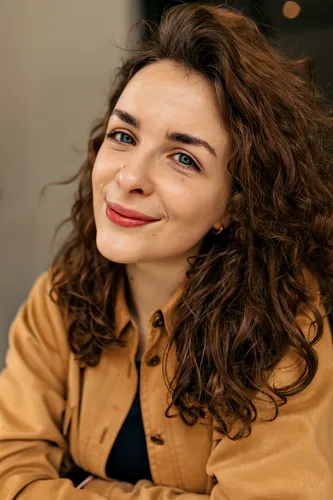 close-up-portrait-tender-lovely-woman-with-curly-hair-nude-make-up-posing-camera-with-lovely-smile-brunette-woman-brown-shirt-feels-good-weekend-home-comfort-concept_komprimiert